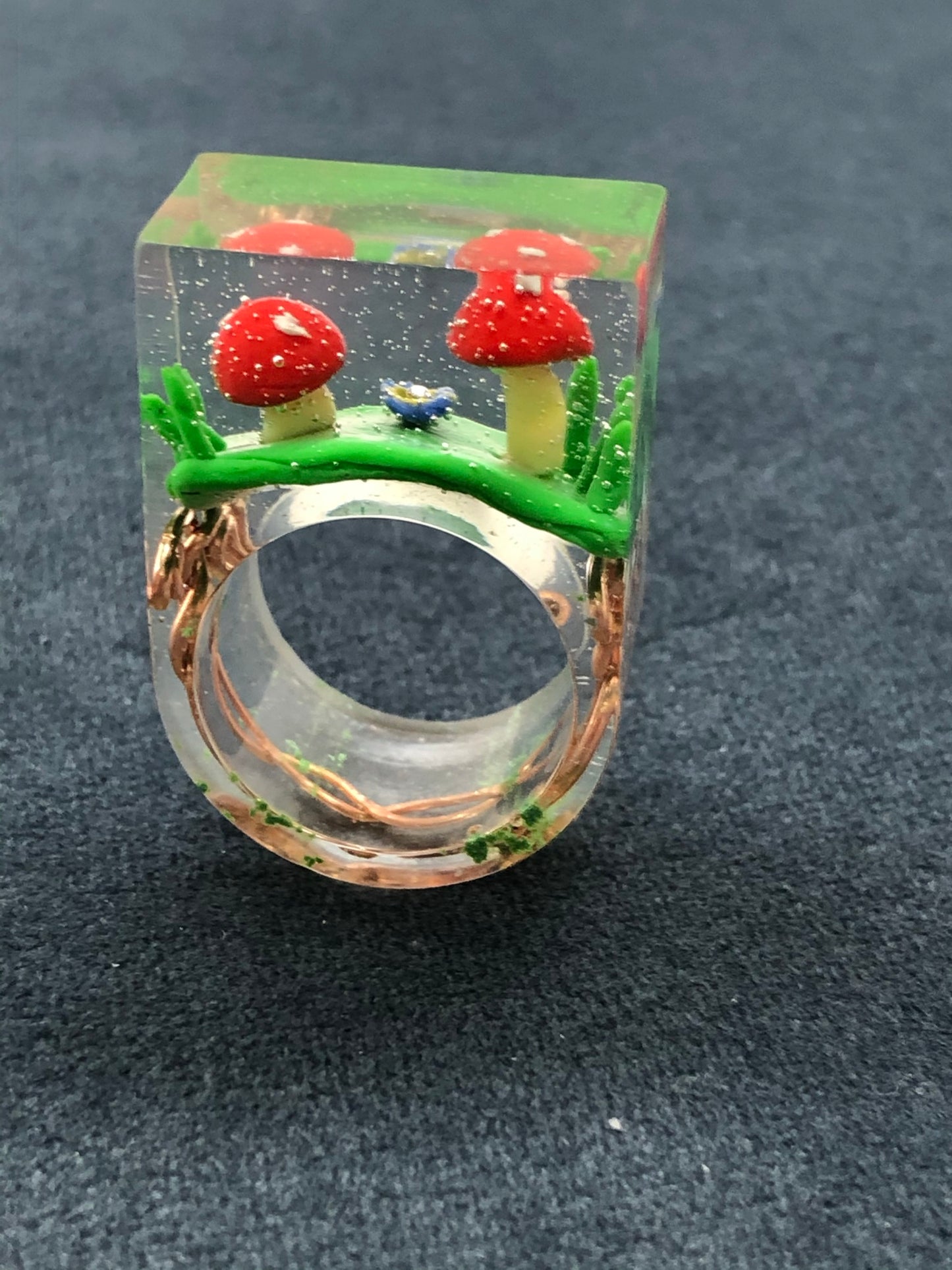 Mushroom Ring hand sculpted mushrooms and entwined copper wire encasedMushroom Ring hand sculpted mushrooms and entwined copper wire encased in hand poured epoxy resin to create this stunning piece. Part of Padpod & Berrie World inresin ringPadpodandberrieMy Fairytale GiftsMushroom Ring hand sculpted mushrooms