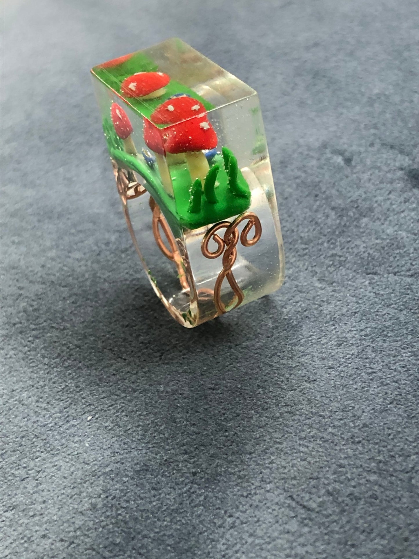 Mushroom Ring hand sculpted mushrooms and entwined copper wire encasedMushroom Ring hand sculpted mushrooms and entwined copper wire encased in hand poured epoxy resin to create this stunning piece. Part of Padpod & Berrie World inresin ringPadpodandberrieMy Fairytale GiftsMushroom Ring hand sculpted mushrooms