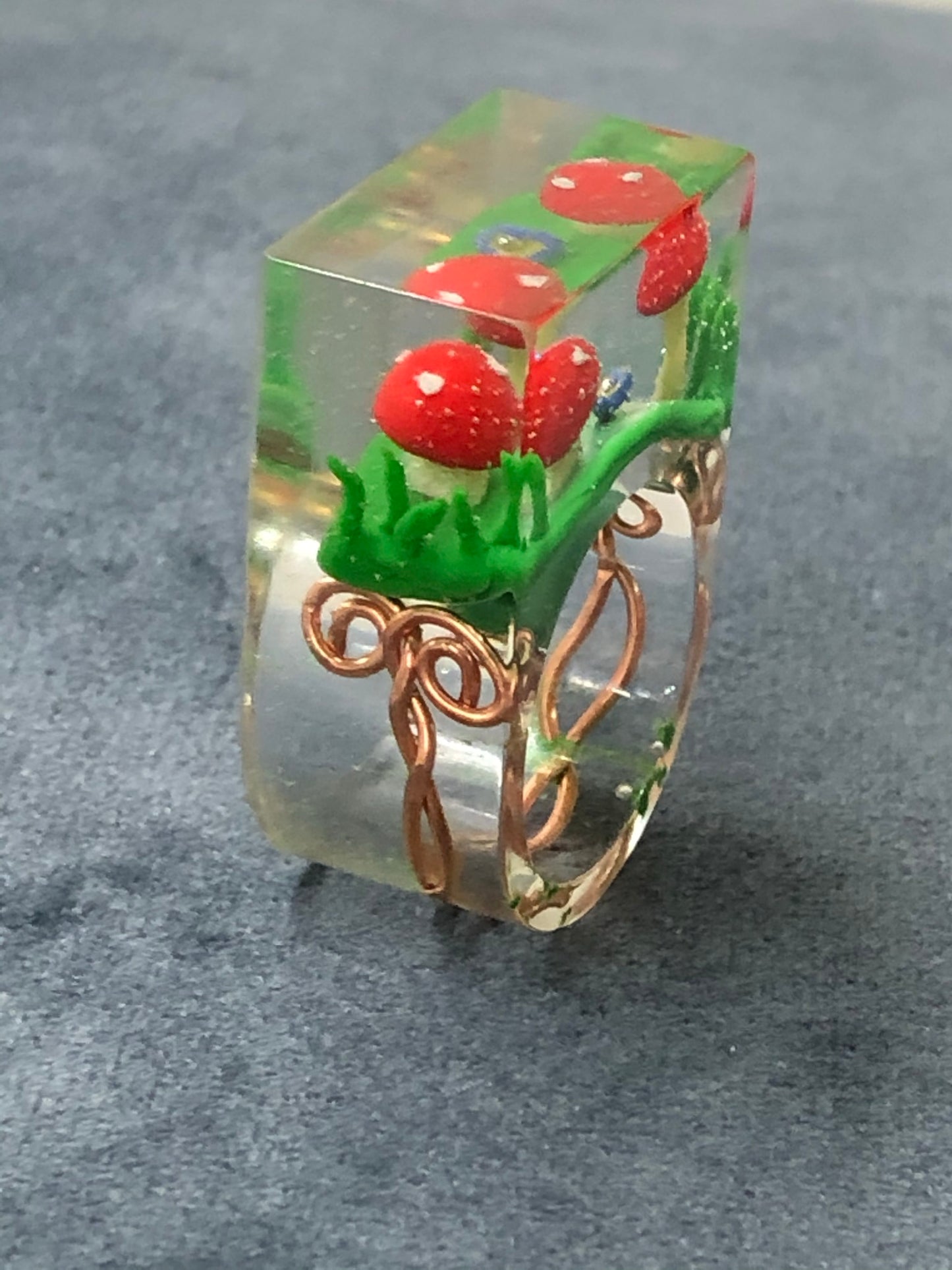 Mushroom Ring hand sculpted mushrooms and entwined copper wire encasedMushroom Ring hand sculpted mushrooms and entwined copper wire encased in hand poured epoxy resin to create this stunning piece. Part of Padpod & Berrie World inresin ringPadpodandberrieMy Fairytale GiftsMushroom Ring hand sculpted mushrooms